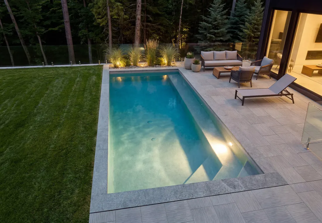 Piscine creusée Trévi Prestige illuminée en soirée